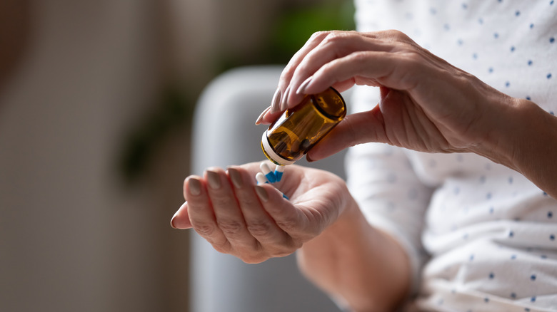 person dumping pills into hand