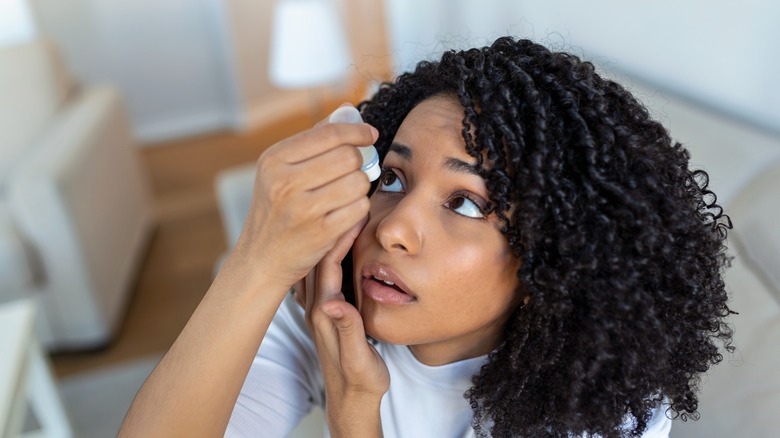 woman putting antibiotic eye drops in eye