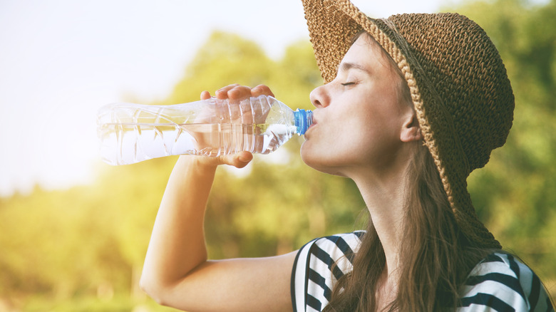 woman drinking from water bottle