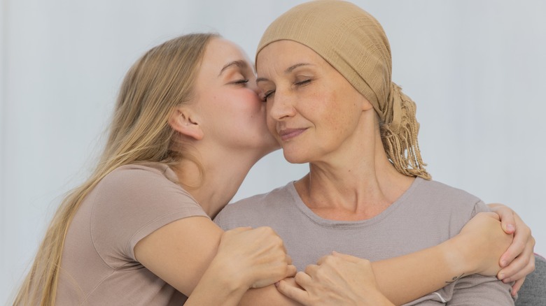 woman hugging mother with a scarf on her head