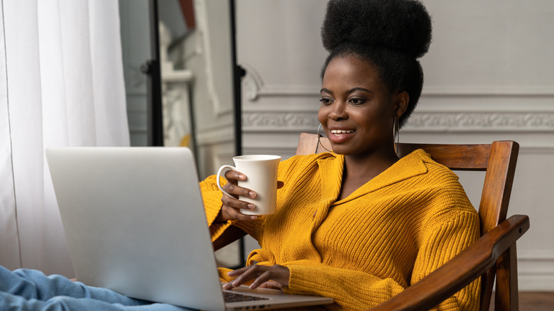 woman at laptop drinking tea