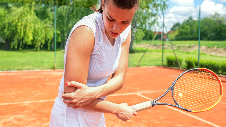 A tennis player clutching her elbow