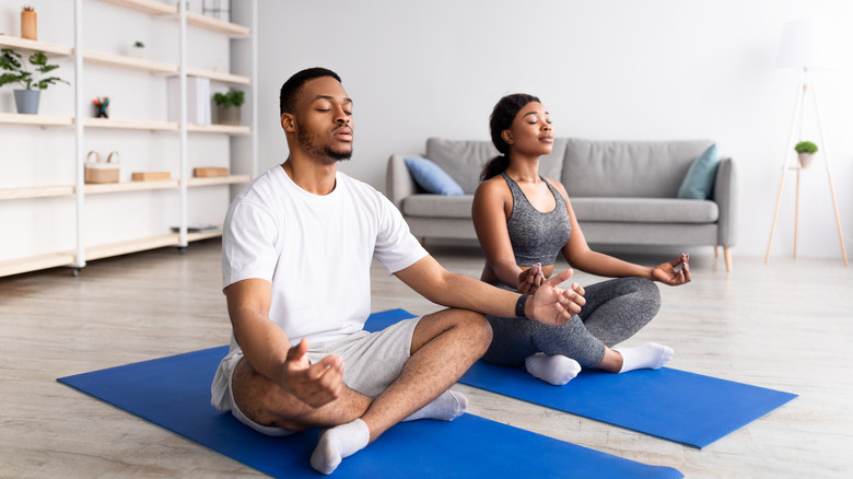 couple meditating on yoga mat