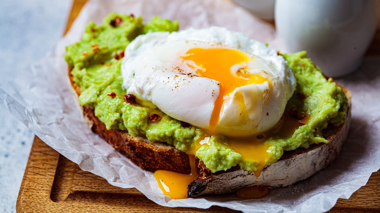 A poached egg with a runny yolk on avocado toast