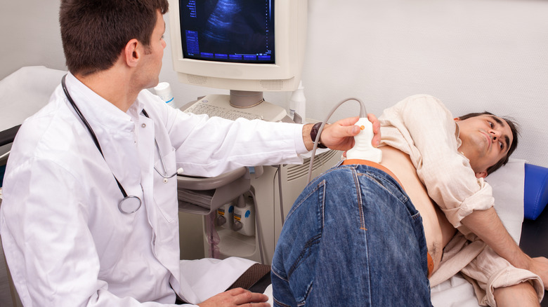 doctor performing ultrasound on man's kidneys