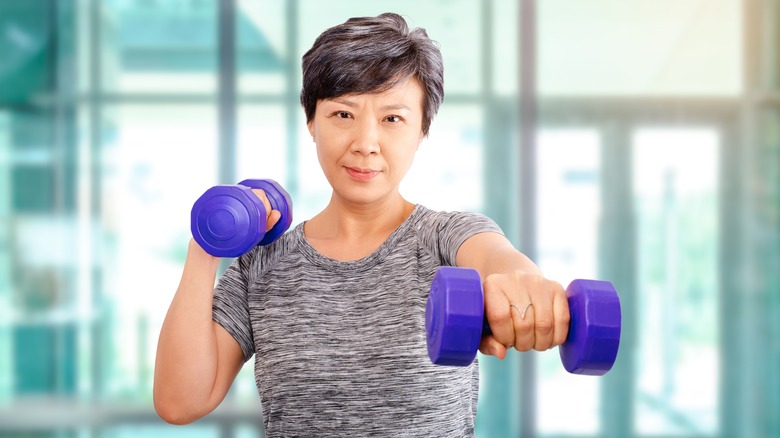 Old woman using dumbbells