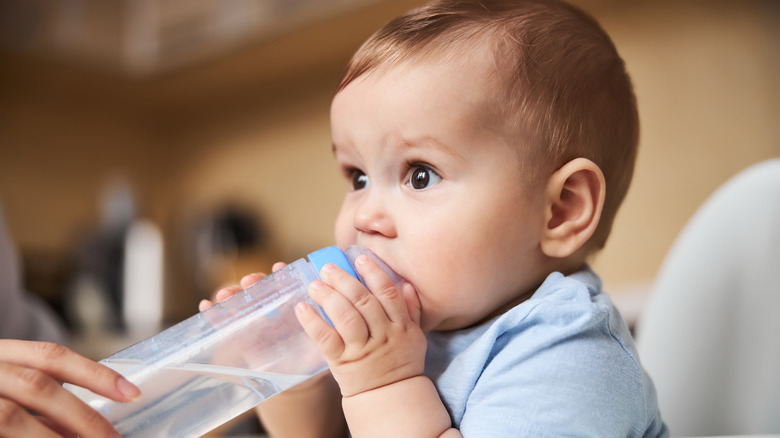 Baby with mouth on water bottle