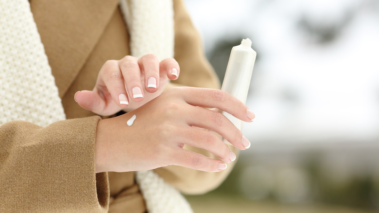 woman putting cream on skin