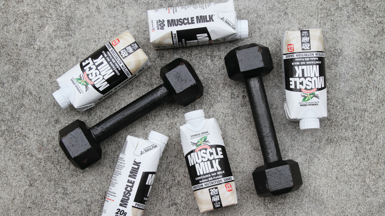 bottles of Muscle Milk ready-to-drink surrounded by small dumbbells