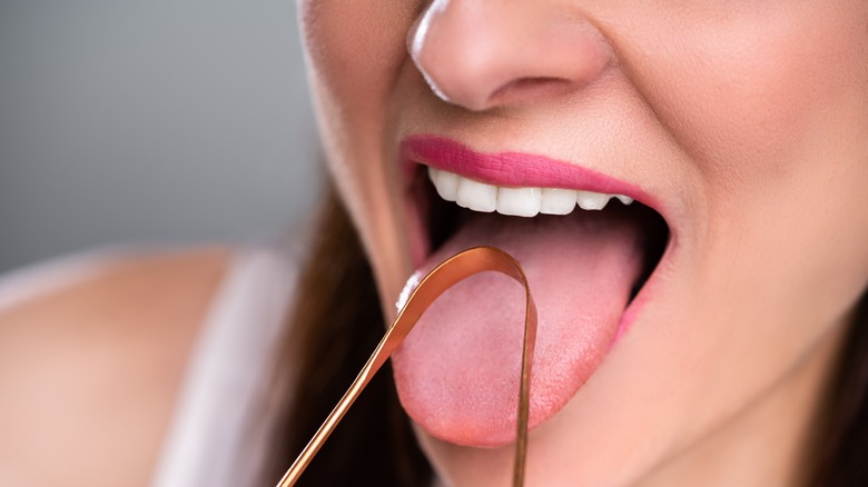 woman using tongue scraper