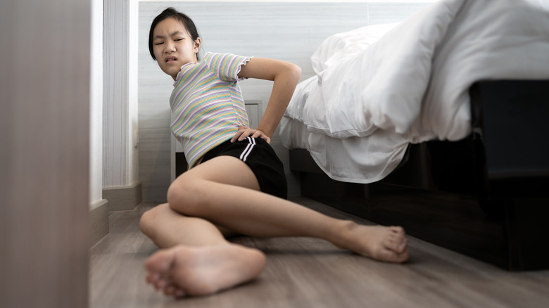 Young woman falling out of bed