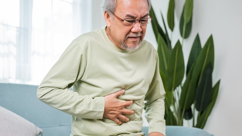 Older man holding stomach in pain