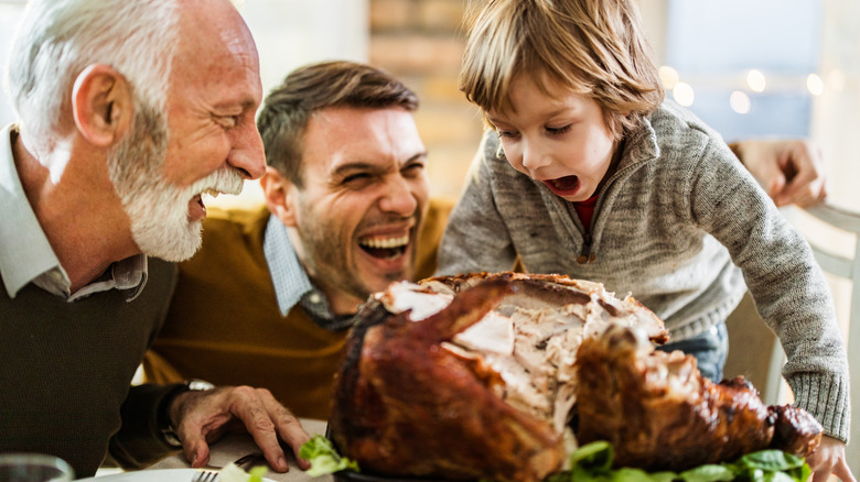 boy, father, and grandfather eating turkey