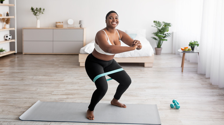 Woman squatting with resistance band