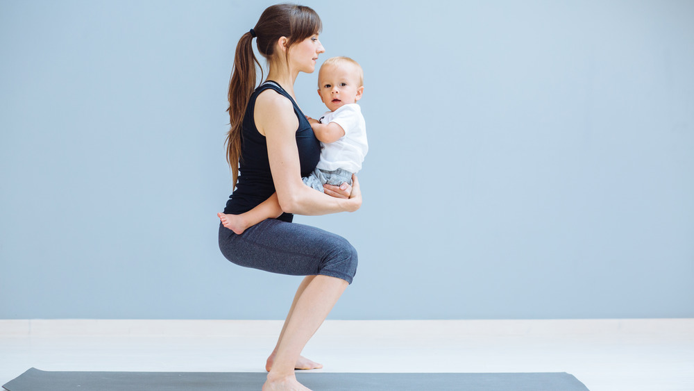 woman squatting with child