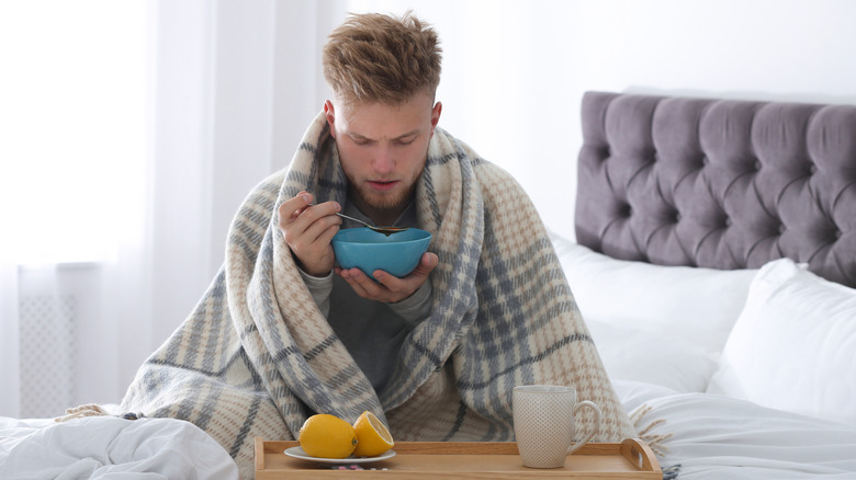 Sick man drinking soup