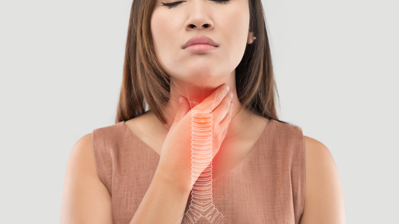 woman holding her throat from acid reflux