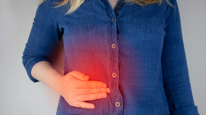woman holding her stomach indicating pain 