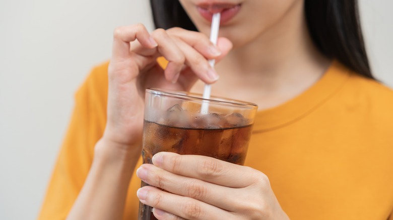 close-up of woman's face drinking soda