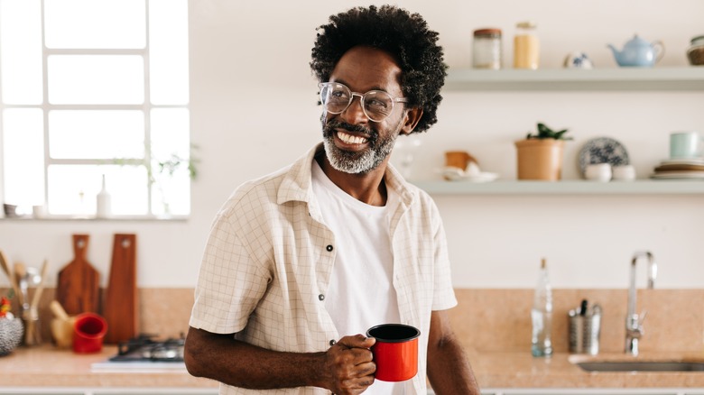 Smiling man holding coffee mug