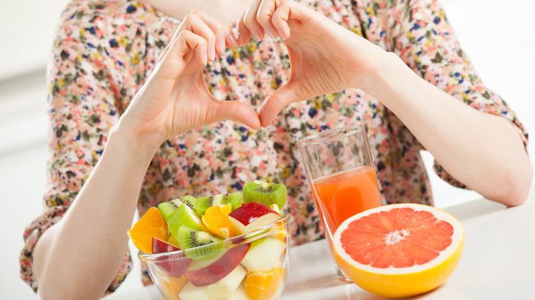 Woman's heart fingers with grapefruit juice