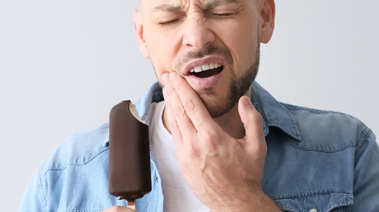 Man with sensitive teeth eating ice cream