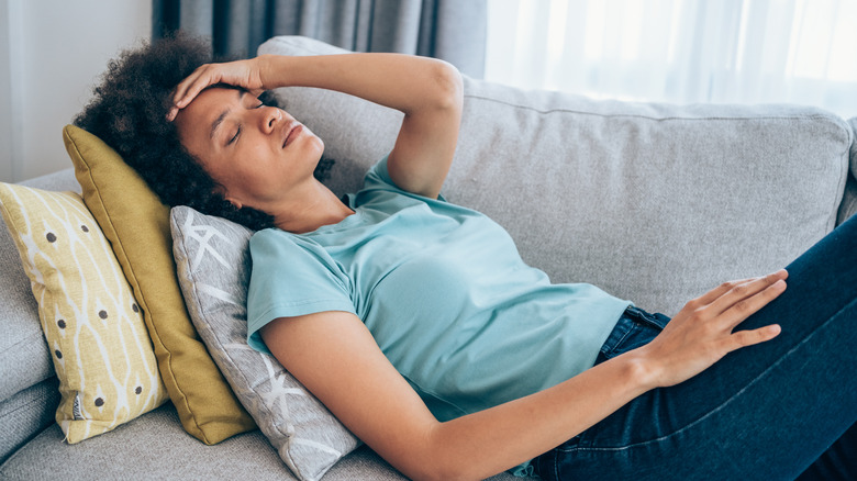 Woman lying on the couch with a headache