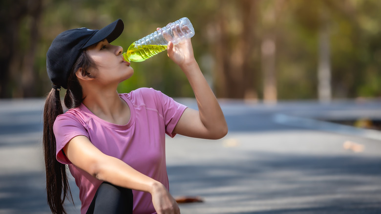 woman drinking electrolyte water after a workout