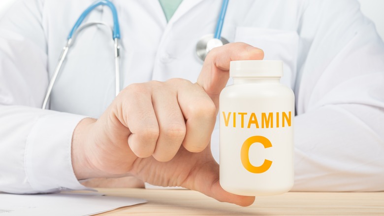 Doctor holding Vitamin C supplement