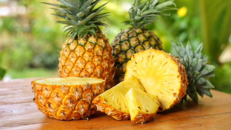 Two whole pineapples and one halved pineapple