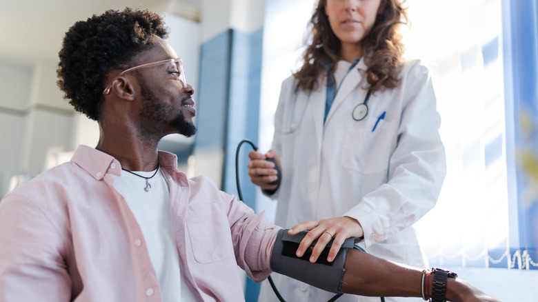 doctor checking patient's blood pressure