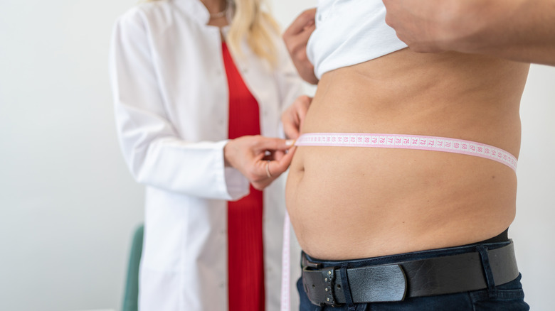 Doctor measuring patient's waist