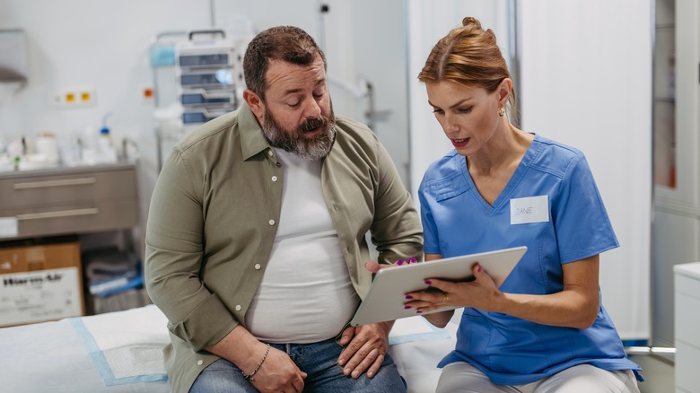 Female doctor consulting with overweight male patient