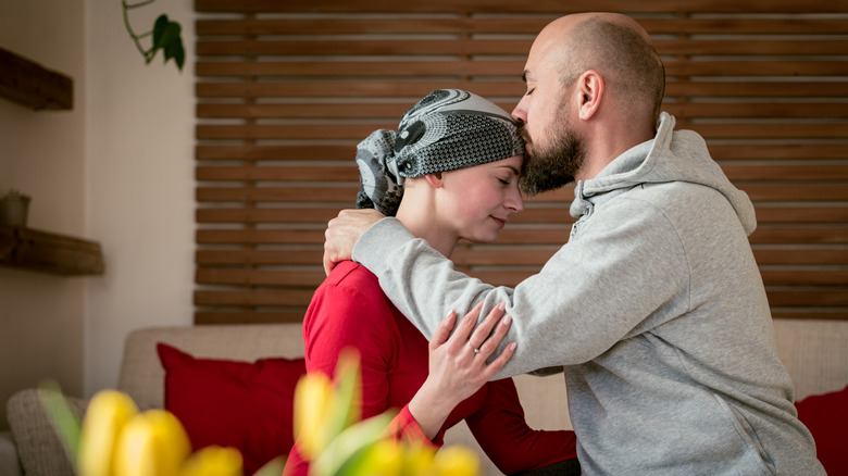 Husband kissing his wife with cancer
