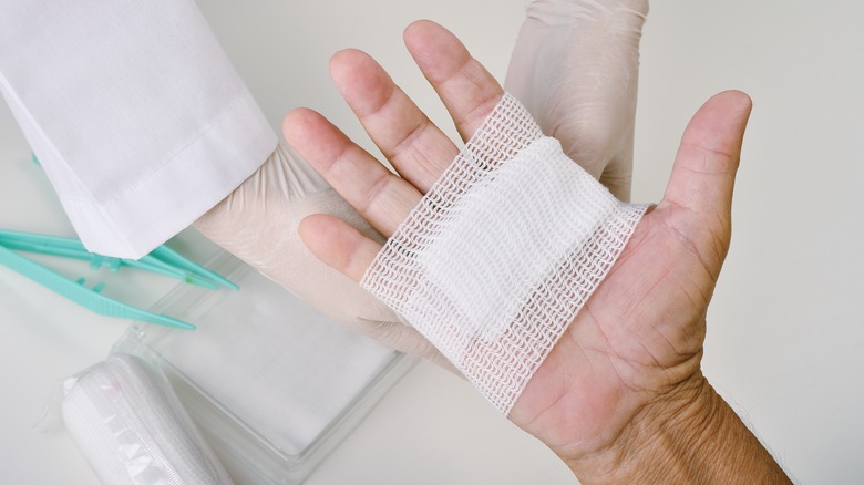 Doctor bandaging patient's hand