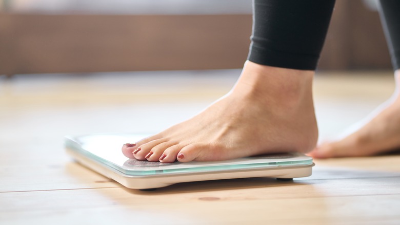 Woman stepping on a weight scale