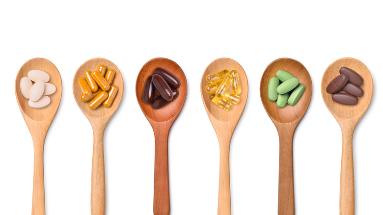 vitamins and mineral pills in wooden spoons