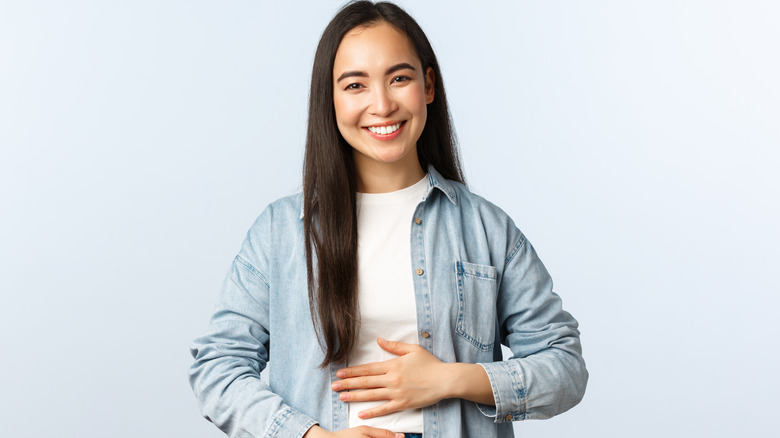 a woman pats her stomach