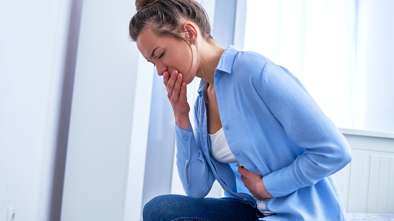 Woman with stomach pain and nausea from food poisoning