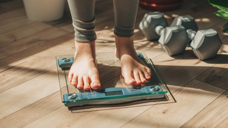 Woman weighing herself on electronic scale