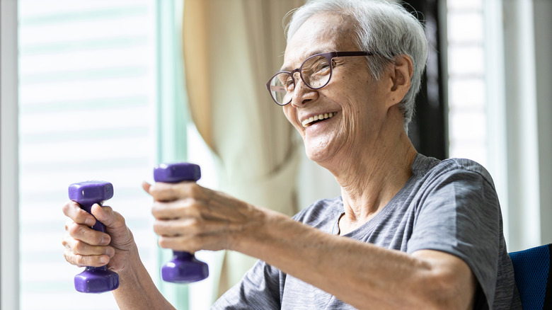 older woman holding weights