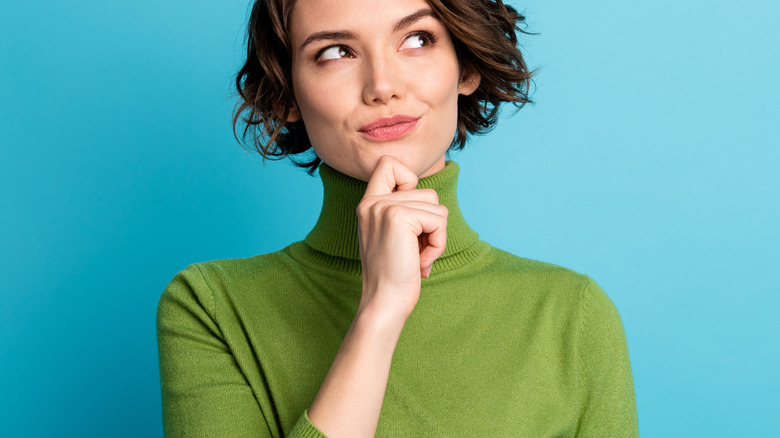 women in green shirt thinking 