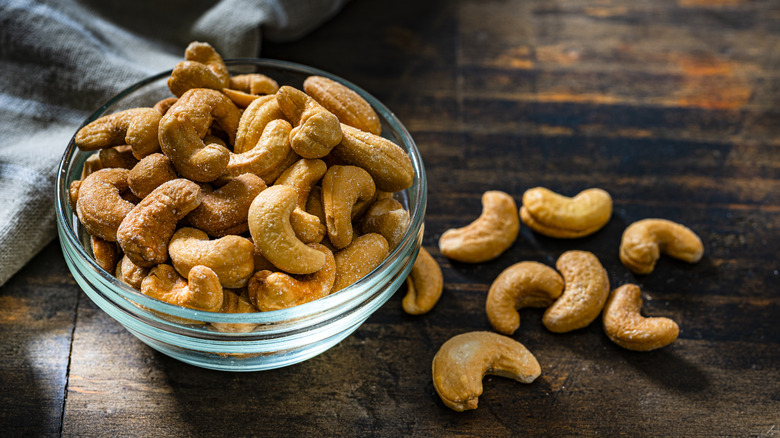 glass bowl of cashews on a wood table