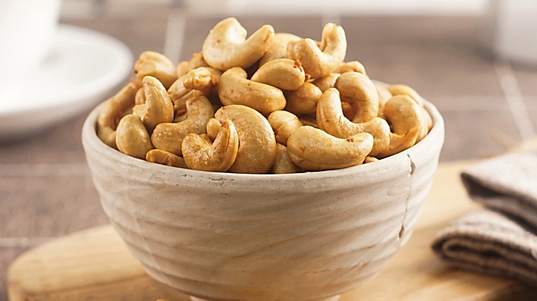 bowl of cashews on a wood tray
