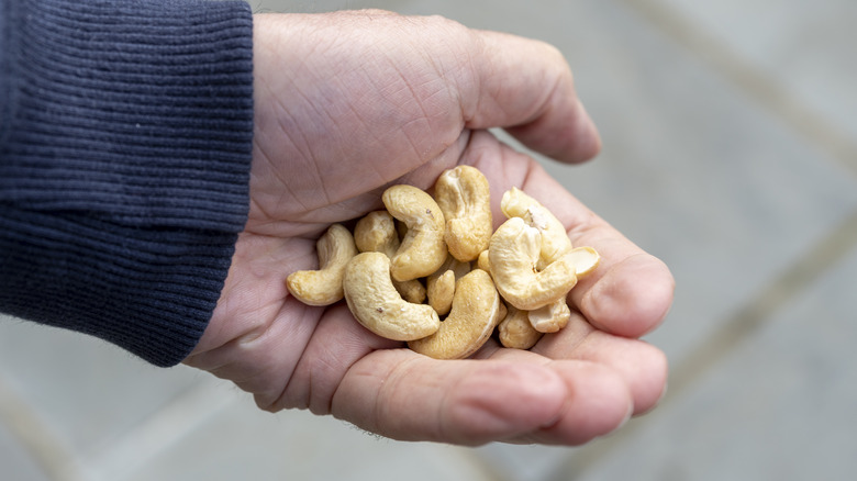 man's hand holding cashews