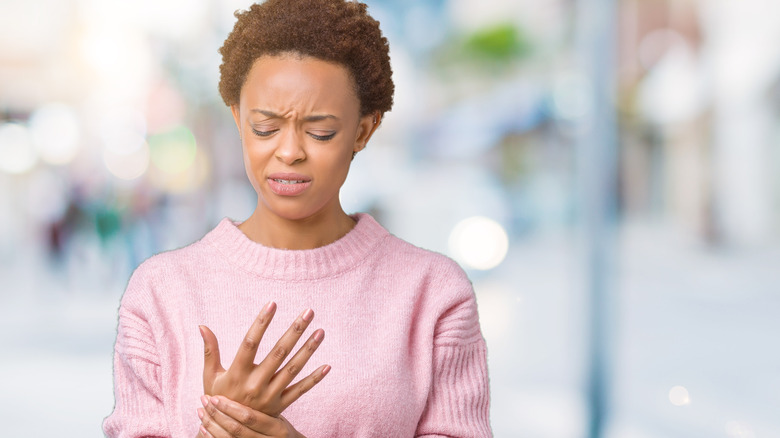 woman holding hand in pain