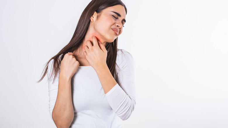 woman scratching at neck