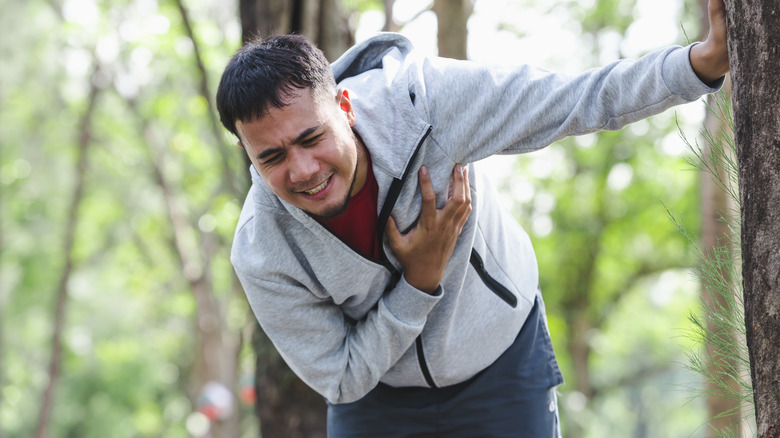 jogging man clutching chest in pain