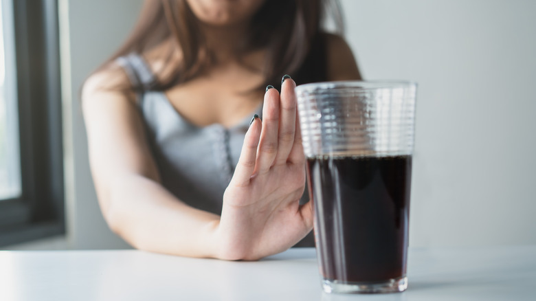 woman outstretched palm says no to soda