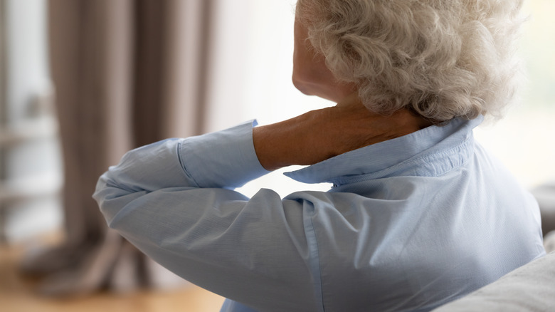 woman with osteoarthritis rubbing neck